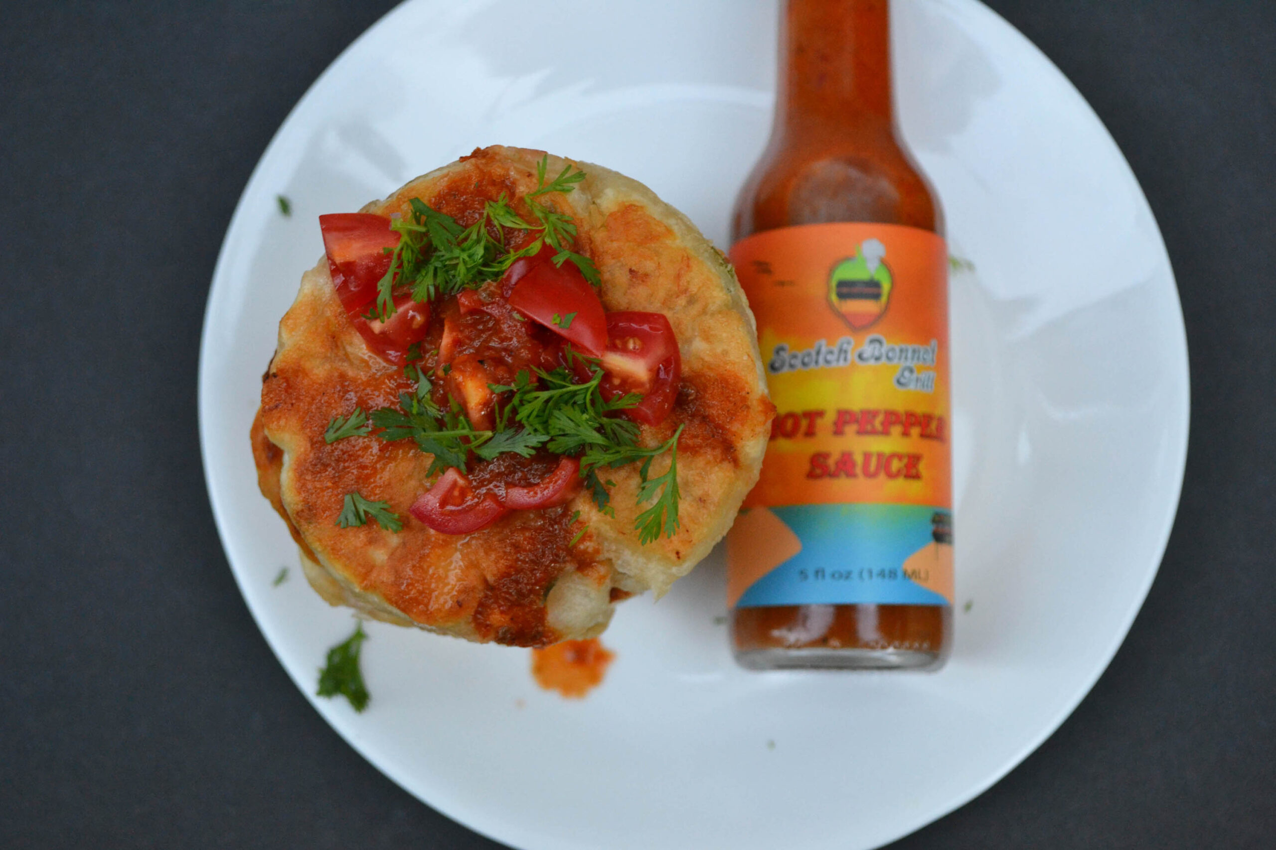 Codfish fritters stack and kissed by Hot Pepper sauce